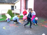 Děti kreslí na asfalt křídami
